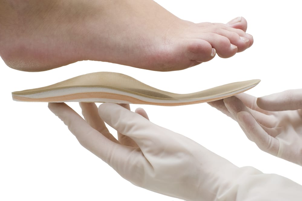 image of gloved hand lifting orthopedic support to foot